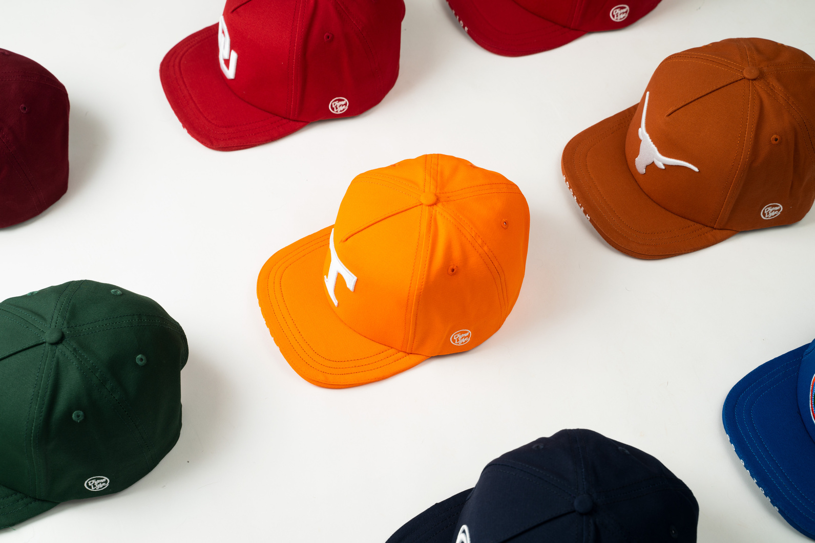 $Bill hats in team colorways laid out on a flat lay